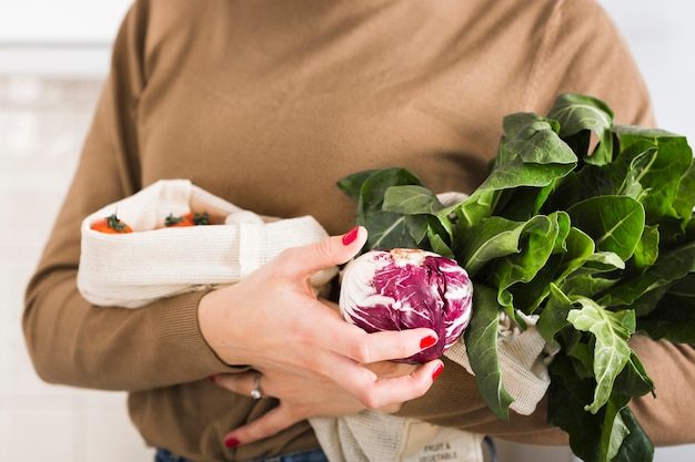 close-up-woman-holding-organic-vegetables_23-2148493606-3578717