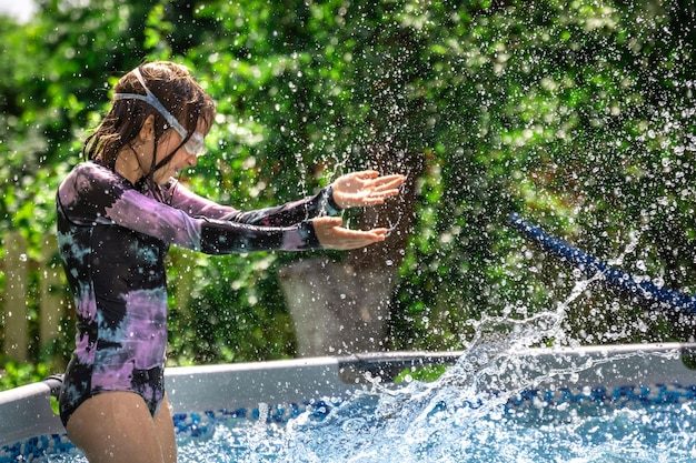 little-girl-playing-swimming-pool-summer-garden_169016-37510-9873474