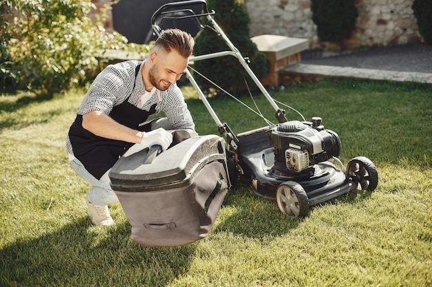 man-cutting-grass-with-lawn-mover-back-yard-male-black-apron-guy-repairs_1157-41434-8409883