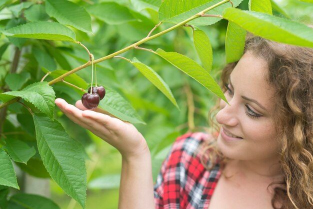 beautiful-woman-farmer-holding-cherry-fruit-green-orchard_342744-845-4227616