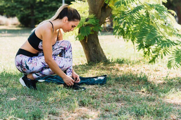 side-view-young-woman-garden-tying-her-shoelace_23-2147944652-7158660