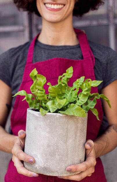 woman-holding-plant-white-pot-close-up_23-2148509899-9066845